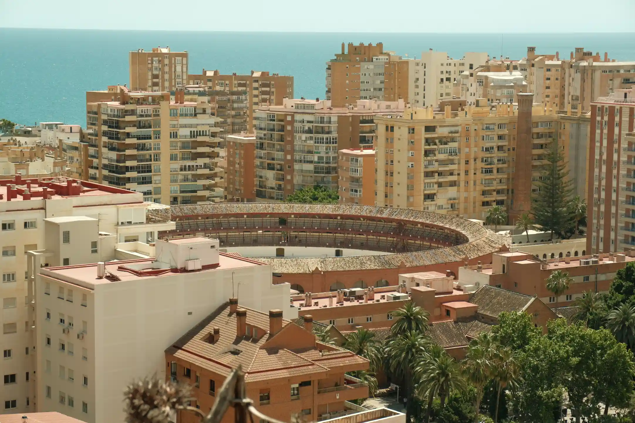 Sunlit Spanish street with cafes and balconies